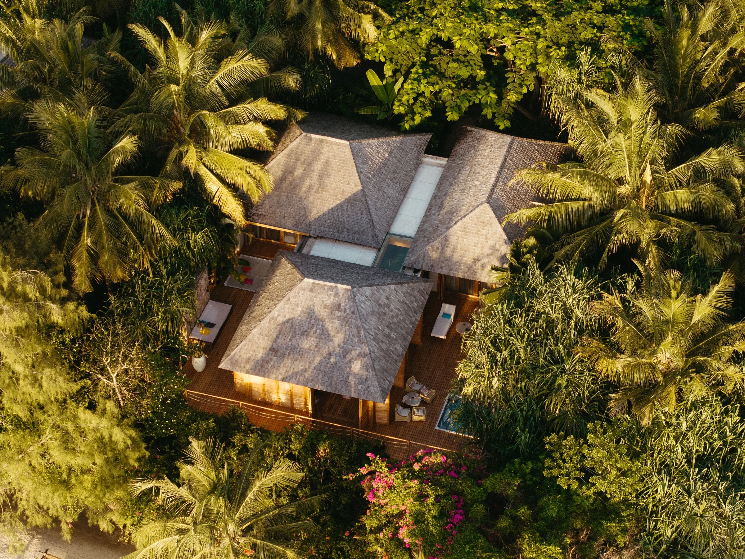 Luftaufnahme einer Villa mit Reetdach und Pool, umgeben von Palmen und Dschungel auf Koh Phangan